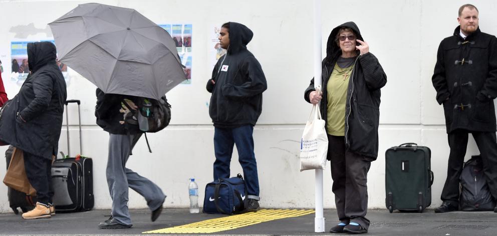 Dunedin resident Anne Marie Parsons (second from right) stands in the rain at Dunedin’s regional...