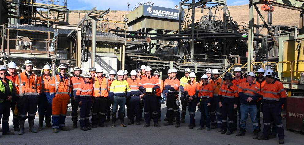 Oceana Gold employees gather with the gold bar containing the five-millionth ounce of gold, which...