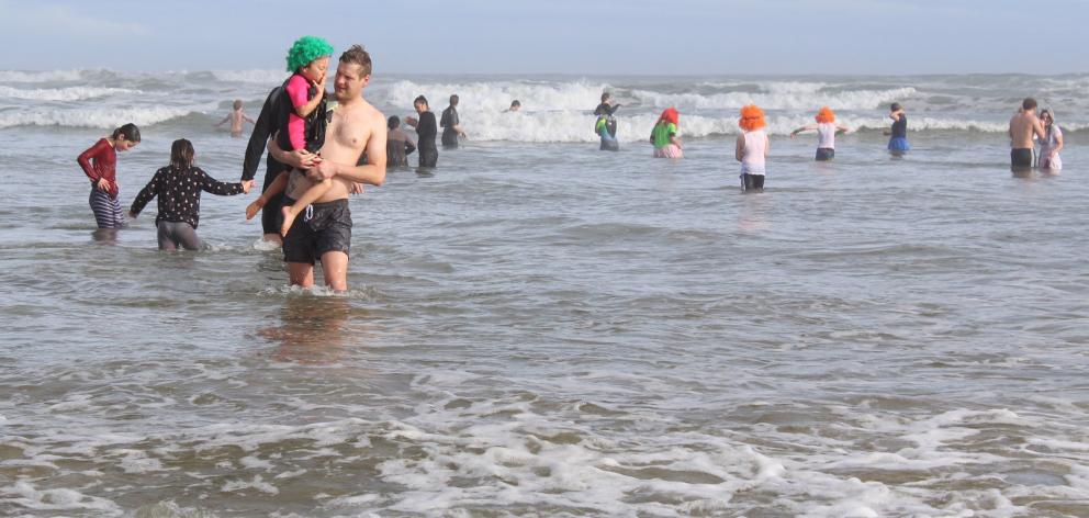 Finished for the day, Sam Greiving and Meila (5) headed out of the water after taking the plunge....