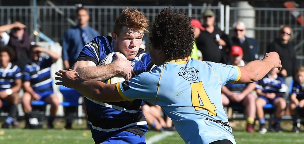 Kaikorai first five-eighth Ben Miller fends University lock Ben Reidy during a premier game at...