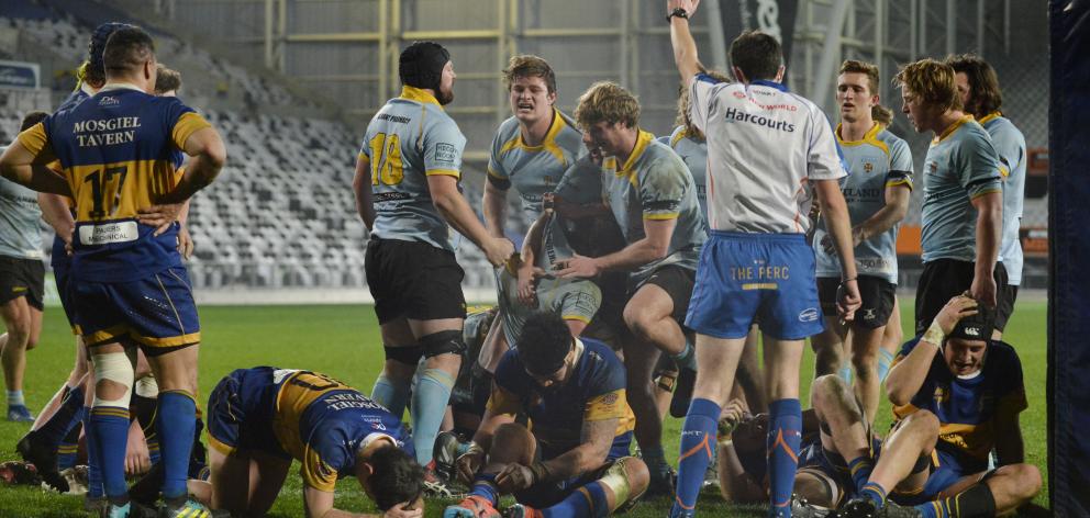 University players are thrilled after Angus Williams (centre) scores the match-winning  try...