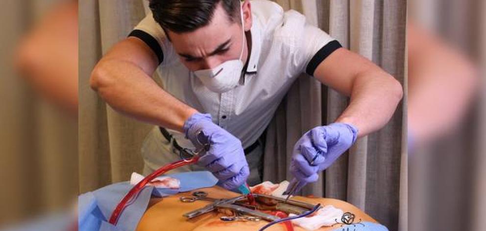 The birthday man performing surgery on his 21st cake. Photo / Make Pretty Cakes Instagram