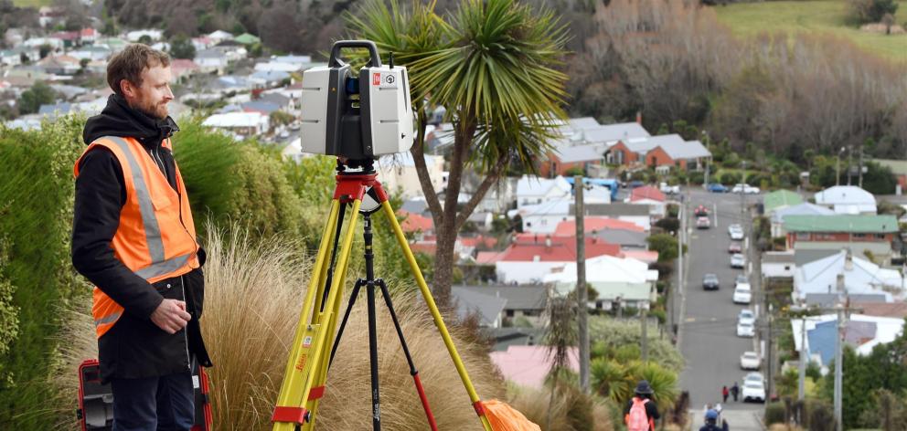 Global Survey New Zealand technical specialist Lennon Bedford takes the most  accurate measurement so far of Baldwin St using a Leica 3-D laser scanner collecting up to a million data points. Photo: Stephen Jaquiery