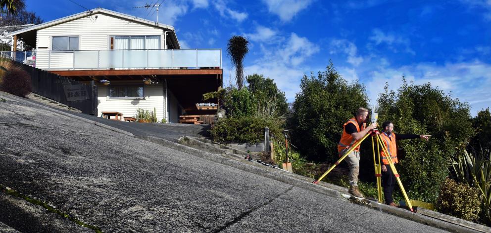 Dunedin surveyors Dylan Hills (left) and Toby Stoff start creating a super-accurate model of Baldwin St as part of their battle against Guinness World Records to reclaim the street's crown as the world's steepest. Photo: Peter McIntosh