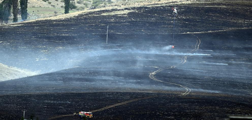 Battling a scrub fire in the Maniototo yesterday as it ravaged tussock and scrubland are a...