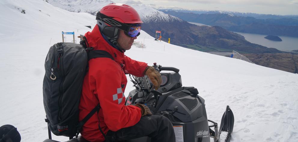 Treble Cone skifield patroller Erik Besselman carrying a backpack of explosives to trigger any...