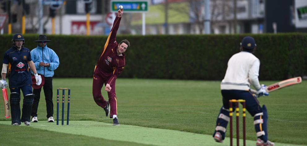 North East Valley's Corey Perrett bowls to Taieri's Cam McAuslan, as Dale Phillips watches at the...