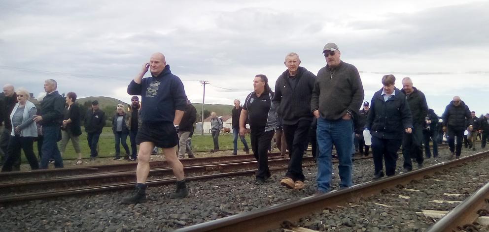 Affected family members and friends walk along the Main South Line at Waipahi Station, as part of...