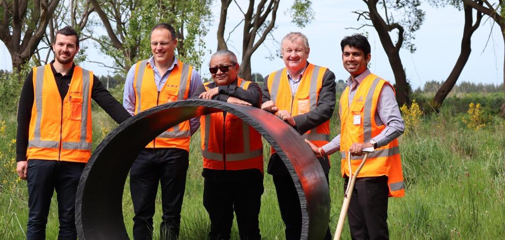 From left, with a section of pipe similar to that to be put underground, are Gareth McGrath and...