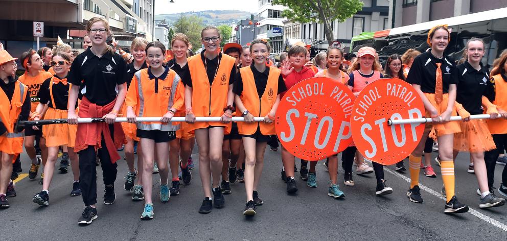 School traffic patrol team members are all smiles as they parade along George St dressed in...