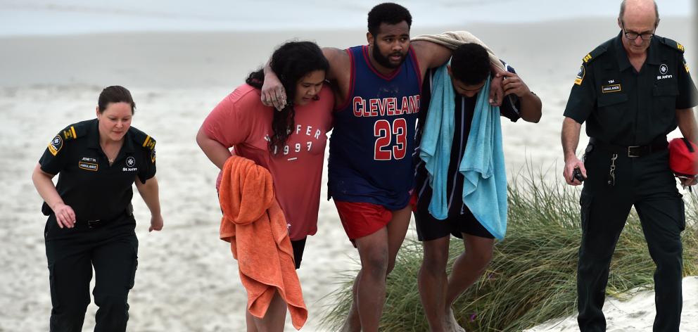 Lua Rasmussen (second left) helps Mosese Dolodolotawake (centre) ashore after the pair were among...