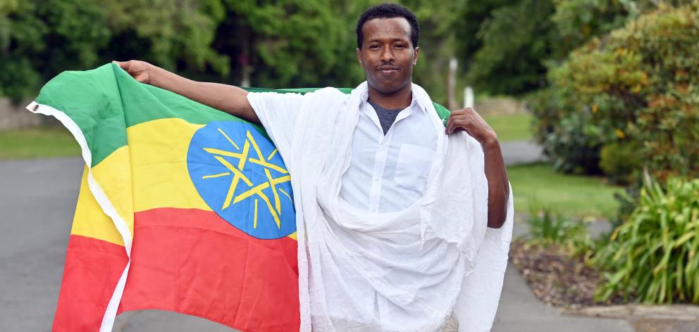 Gebre Gebresdik shows evidence of his birthplace, Ethiopia, outside the Grace Bible Church. PHOTO...