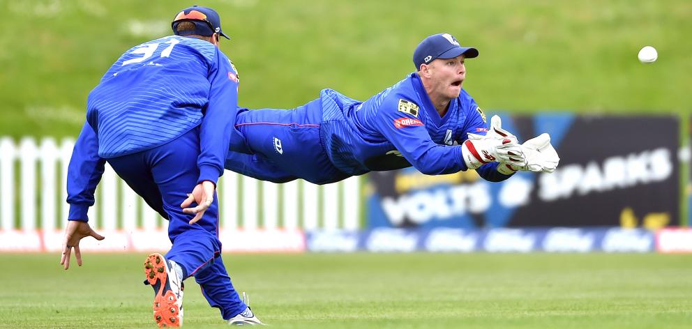 Auckland wicketkeeper Glenn Phillips catches out Otago batsman Neil Broom while watched by Martin...