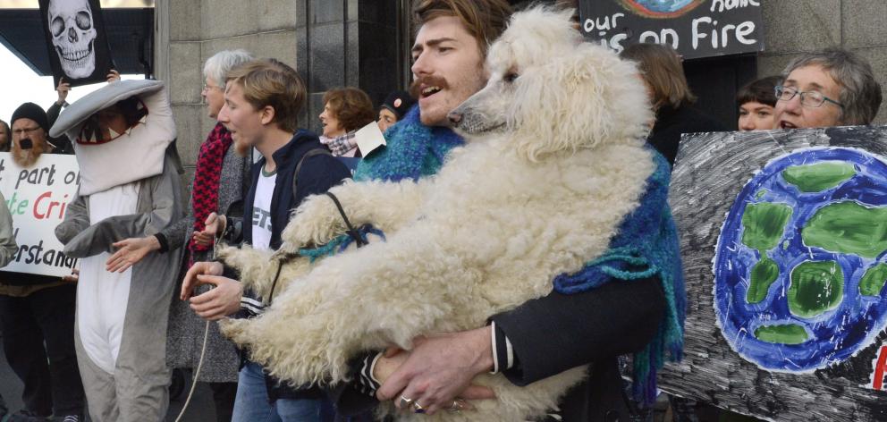 Jack Brazil and his standard poodle Saffron Squish join other demonstrators protesting against an...