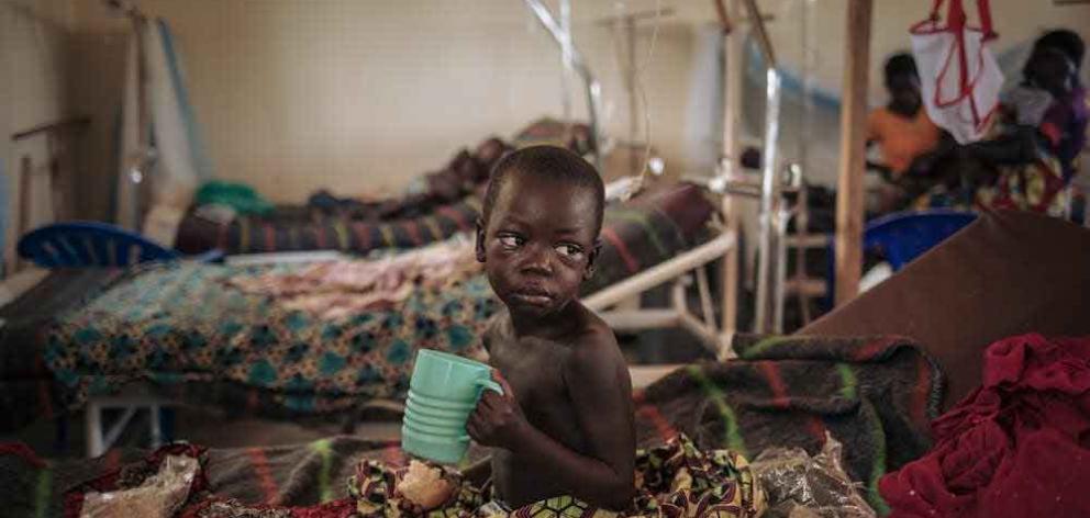 Moraku Tabhu, three-and-a-half years old, who suffers from measles, eats in the measles unit run...