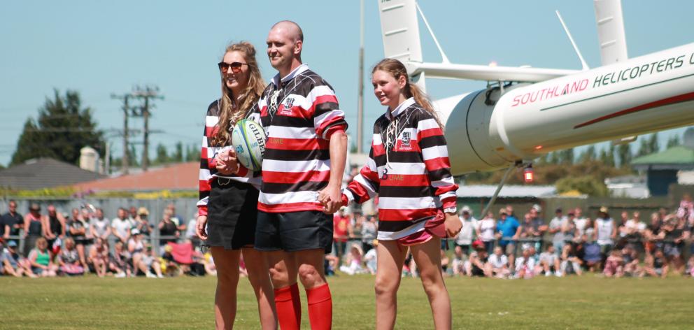 Blair Vining arrives at his bucket list rugby game via helicopter with daughters (from left)...
