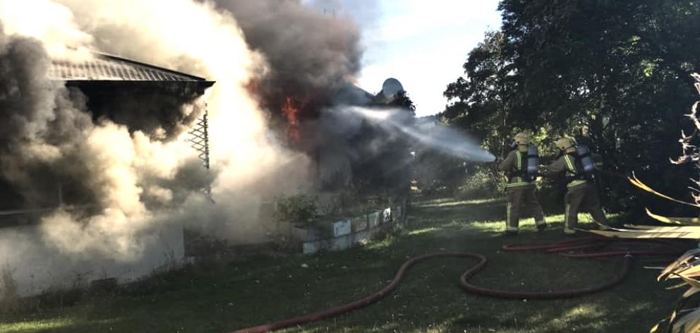 Volunteer firefighters tackle a house fire near Te Anau yesterday. Photo: Te Anau Volunteer Fire Brigade