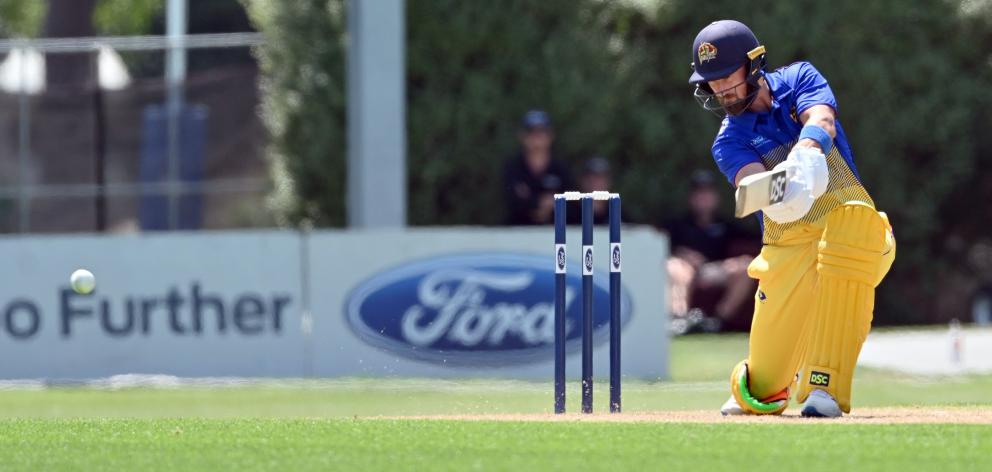Nick Kelly watches his shot for Otago; Otago batsman Neil Broom hits the ball through the covers.