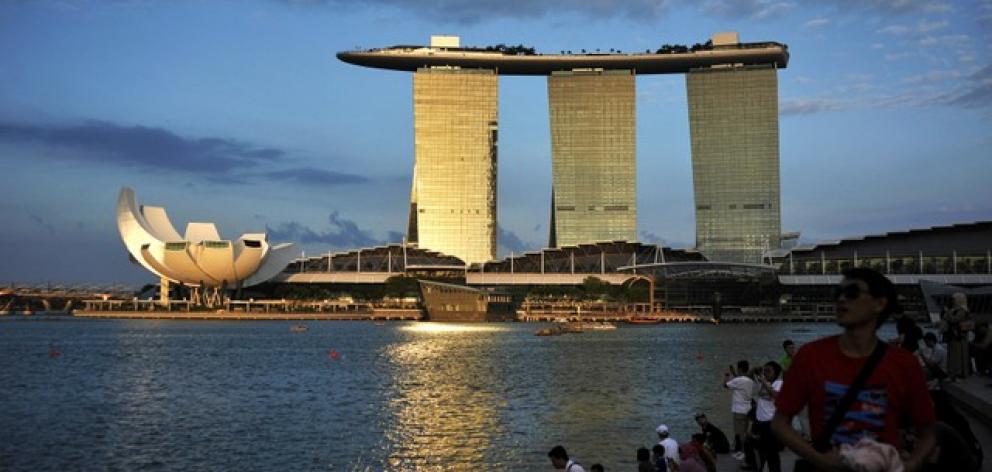 eople sit on the waterfront as sunlight shines on the Marina Bay Sands resort in Singapore. Photo: Reuters