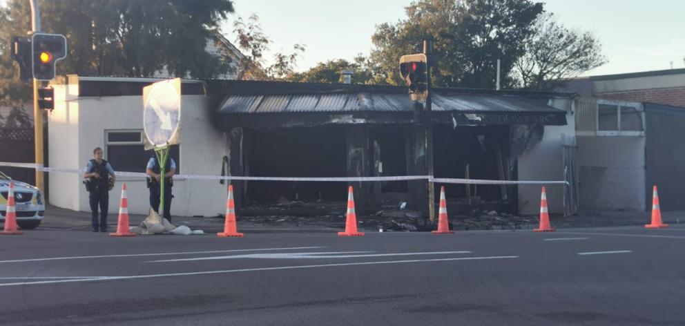 Police stand guard on Monday morning after a fire at Bristol Barbers on Wainoni Rd. Photo: Ian...