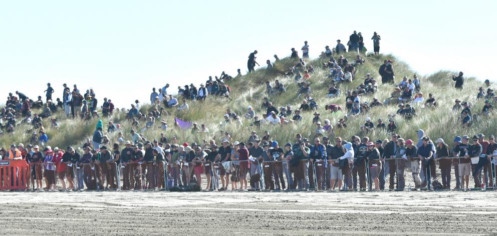 Spectators stand in the sand dunes at the Burt Munro Challenge Indian Motorcycle NZ Beach Racing...