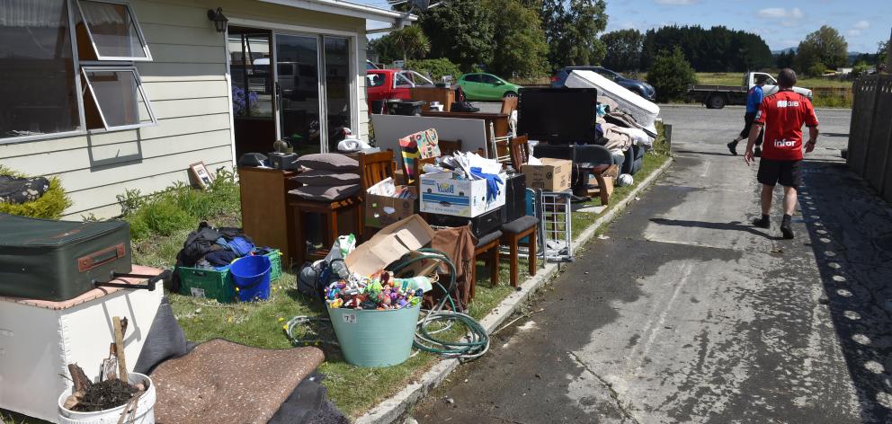 Possessions and household contents are piled outside a house in Mataura that was badly hit by...