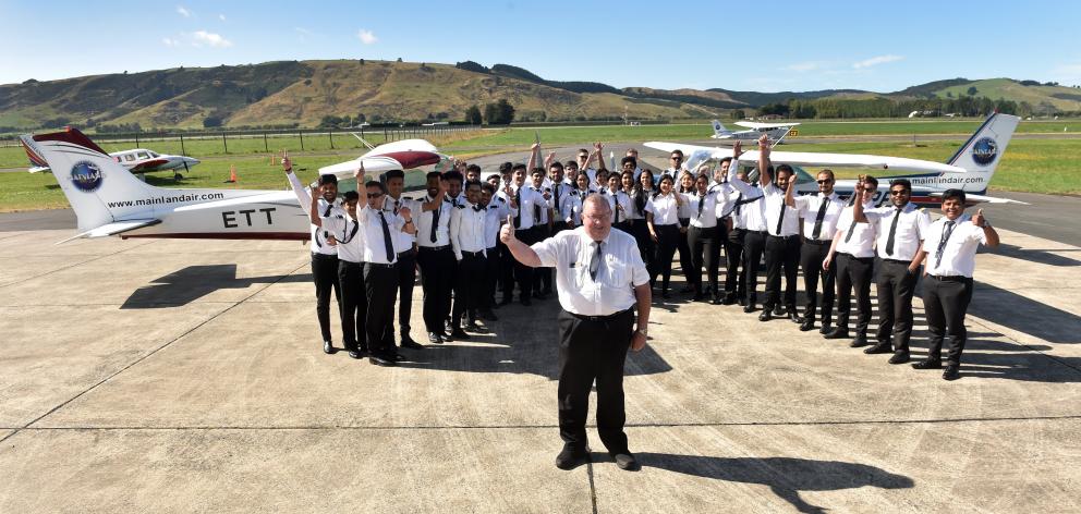 Philip Kean stands in front of some of hte intake of students at Mainland Aviantion College with...