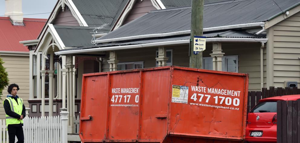 An Allied Security staff member keeps an eye on a skip in Castle St yesterday. PHOTO: PETER...