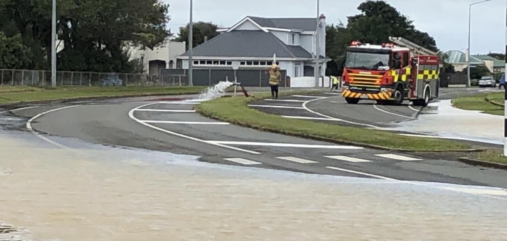Water covers a street in Invercargill as firefighters respond. Photo: Laura Smith