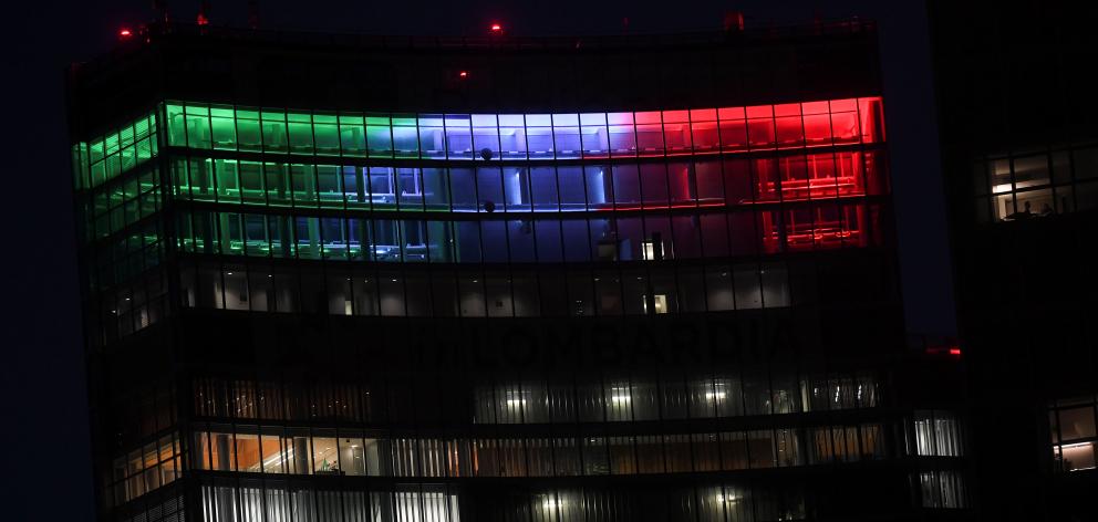The Palazzo Lombardia building is seen iluminated with the colours of the Italian flag in Milan. Photo: Reuters