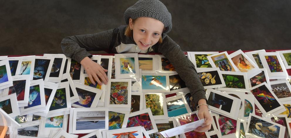 Taking a moment to look at Ian Marechal’s photocards on display, Madeleine Cumberpatch (11), of...