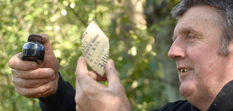 Dunedin military researcher Peter Trevathan holds an ink bottle and a piece of stoneware...