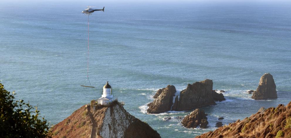 Helicopters Otago pilot, Andy Baird, swings a 350kg load of timber on to a small deck beside the...