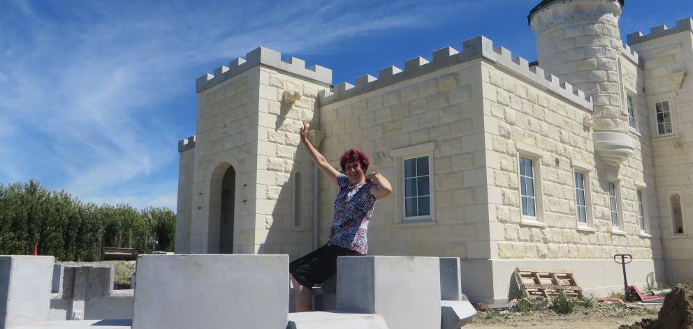 Castle owner Dot Smith examines  one of the castellations to be put atop her creation  today....