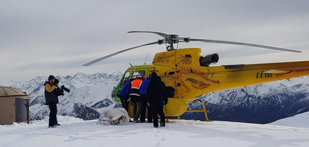 Unloading the helicopter at Mt Saint Just while film-maker Mark Johansson looks on. PHOTOS: ERIK...