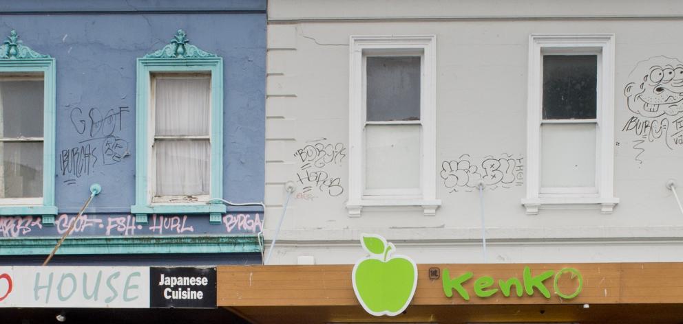 Tagging is removed from the upper storeys of George St shop yesterday afternoon. Photo: Gerard O'Brien Tagging is removed from the upper storeys of George St shop yesterday afternoon. Photo: Gerard O'Brien