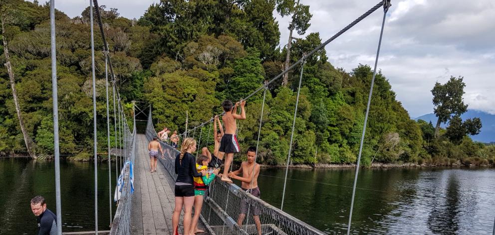 Children jump from the swing bridge over the Arnold River. PHOTO: TONY KOKSHOORN