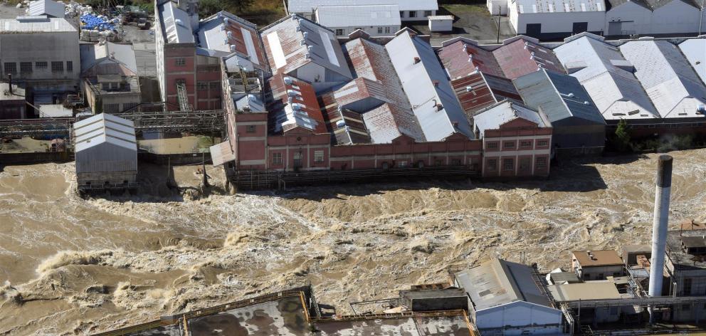 The flooded Mataura River rips past the former Mataura paper mill. Photo: Stephen Jaquiery