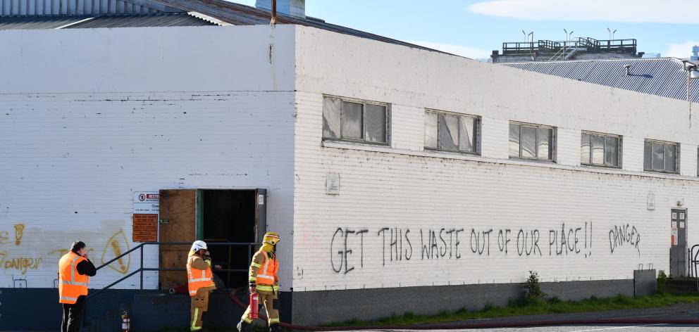 Firefighters at an entrance to the building holding toxic ouvea premix in Mataura. PHOTO: LAURA...