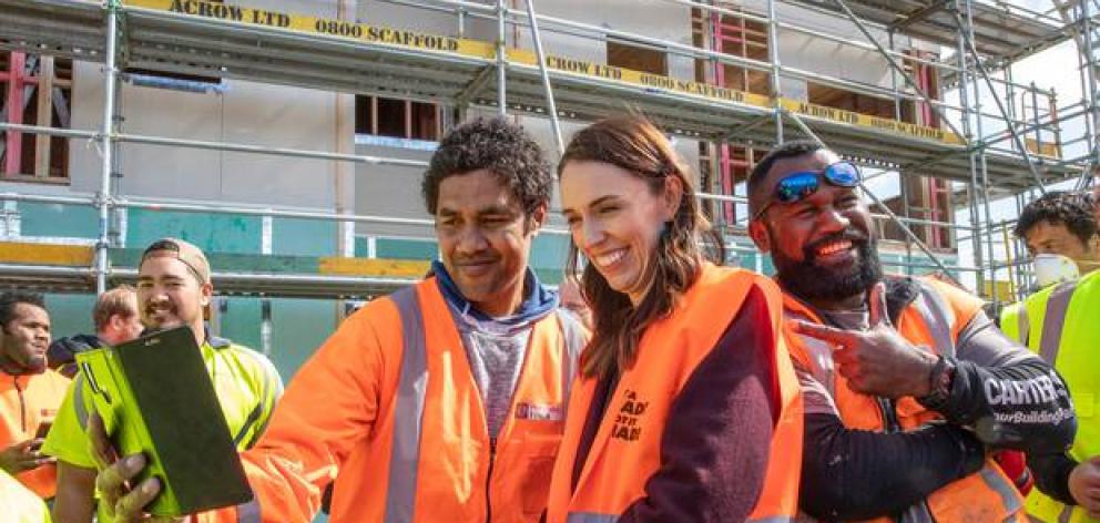 Prime Minister Jacinda Ardern poses for selfies with tradesmen at Isles Construction in Palmerston North last week. Judith Collins claims Ardern is breaking her own rules. Photo: NZ Herald