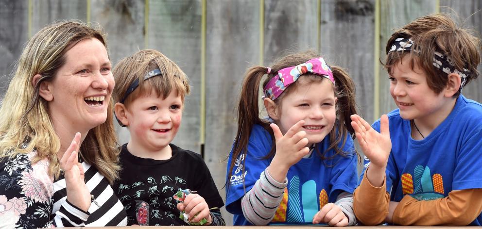 St Kilda Kindergarten teacher Jess Anderson uses sign language to communicate with (from left)...