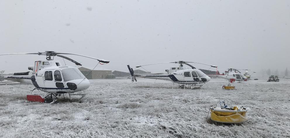 Helicopters used to fight the large fire near Lake Pukaki on the ground in a snow storm at Pukaki...