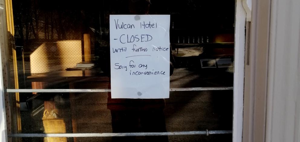 A sign on a window says the historic Vulcan Hotel is closed. 