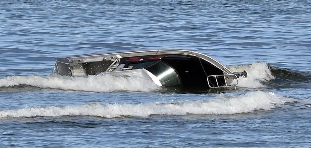 The 6.5m-long boat that overturned on the bar at Taieri Mouth yesterday. PHOTOS: PETER MCINTOSH