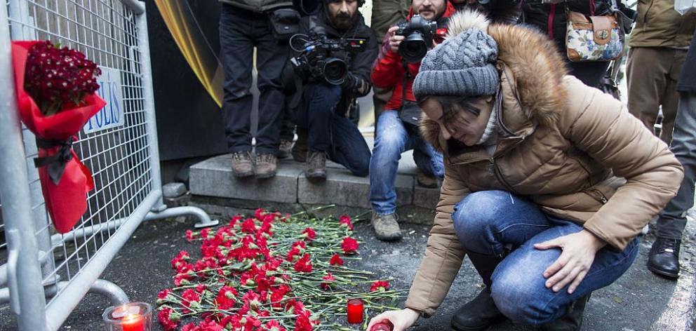 A woman lays flowers and candles and gather in front of the entrance of the Reina nightclub where the shooting took place in 2017. Photo: Getty Images