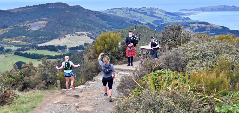 Paula Brown (centre), of Bluff, does an impromptu Highland fling at the peak of Mt Cargill in...