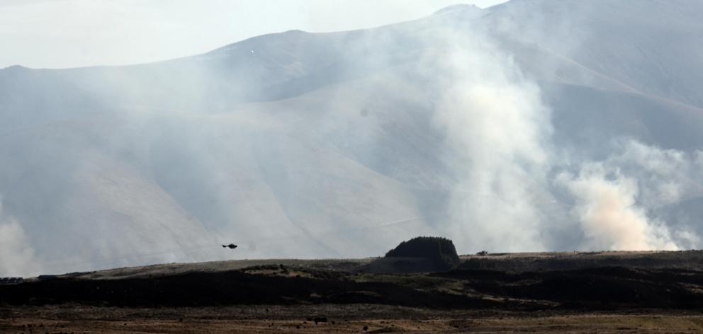 A helicopter fights the fire at Lake Ohau yesterday evening. PHOTO: CRAIG BAXTER

