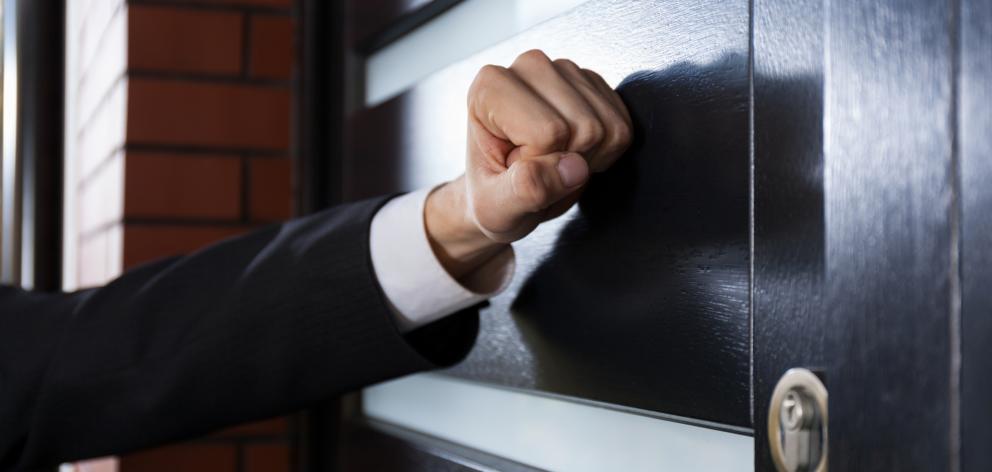 Close-up of hand knocking on the door. Photo: Getty Images