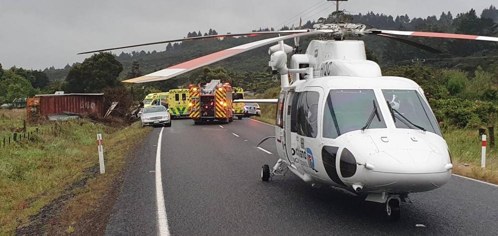 The Northland Rescue Helicopter at the crash scene on SH12 near Omanaia. The shipping container struck by the car can be seen on the left. Photo: NEST