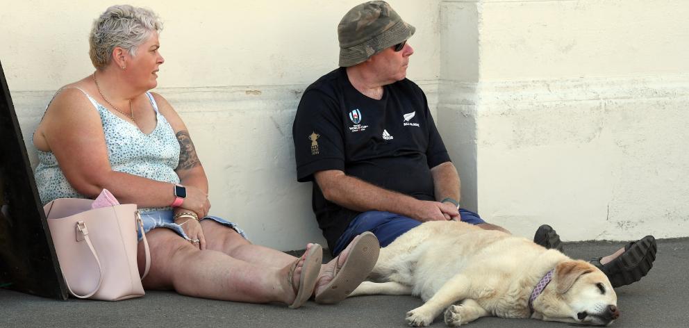 Stephanie and Jason Jeffs, of Christchurch, have a break in the shade with their sleeping dog...